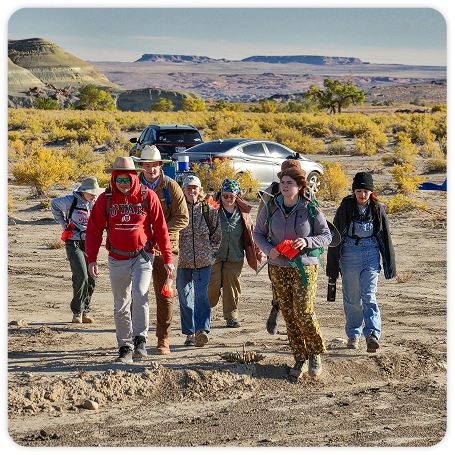 Photograph of college students hiking to an archaeological site.